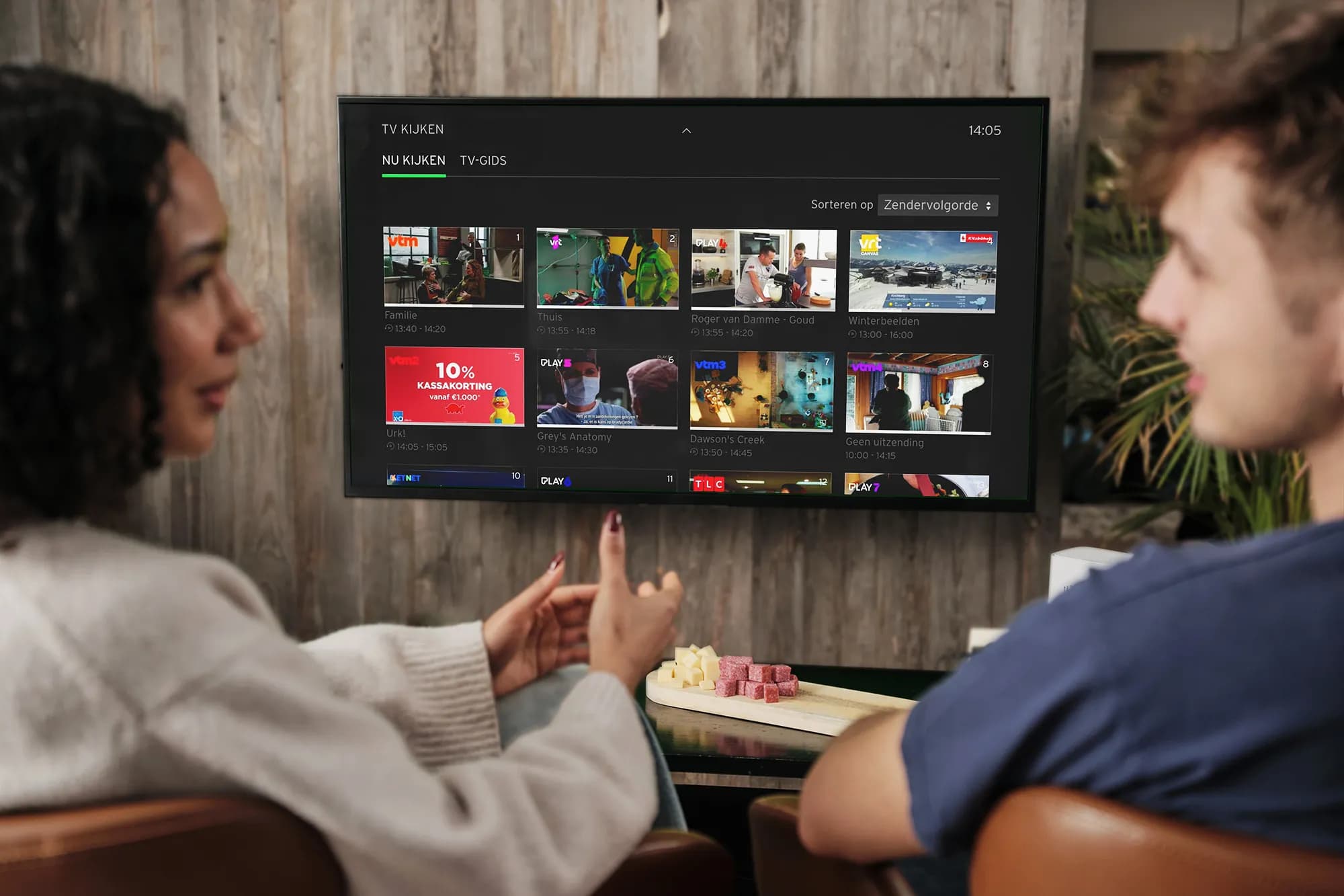 A man and woman talking while watching TADAAM TV
