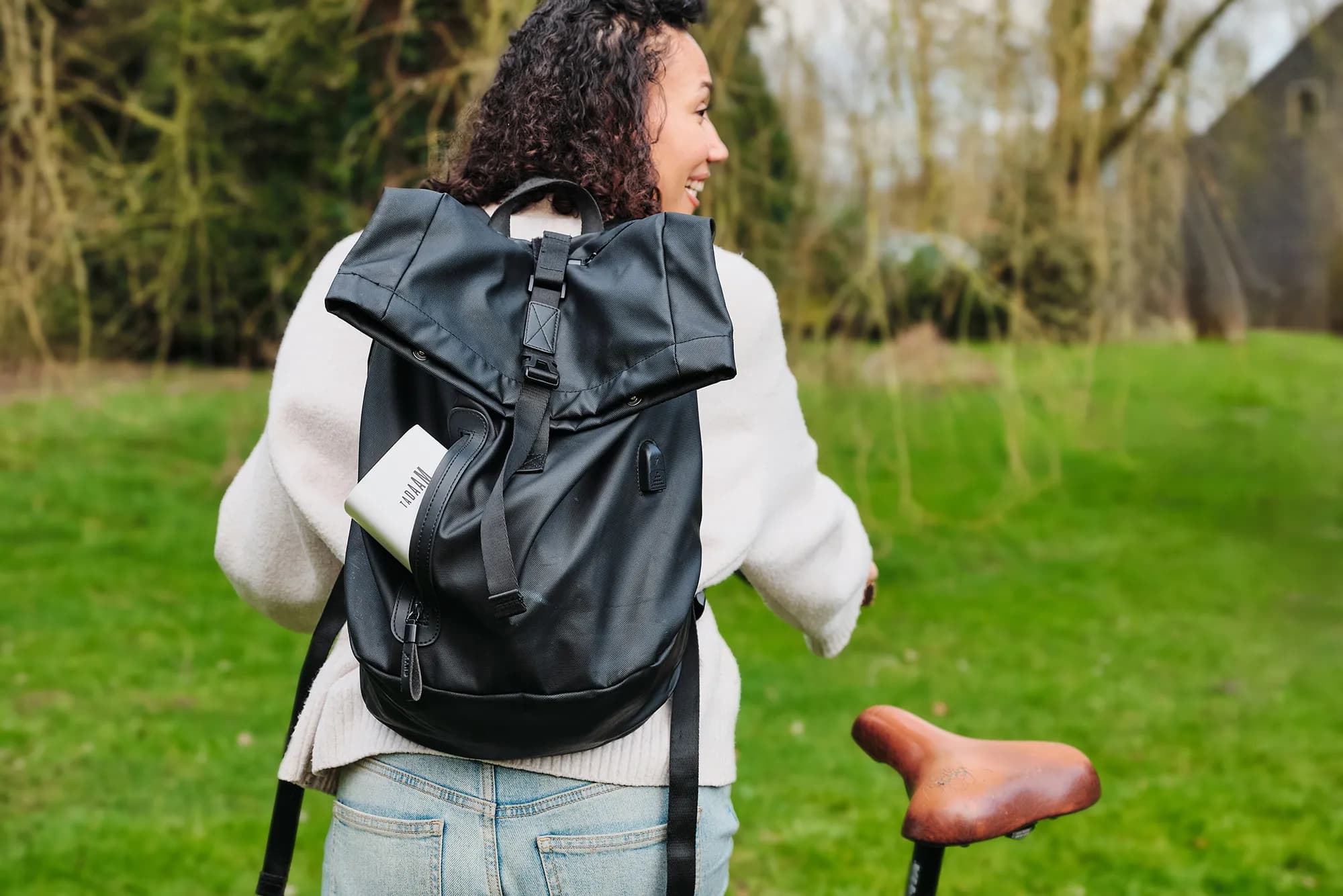 An image of a person walking with a bike and a TADAAM modem in the backpack.